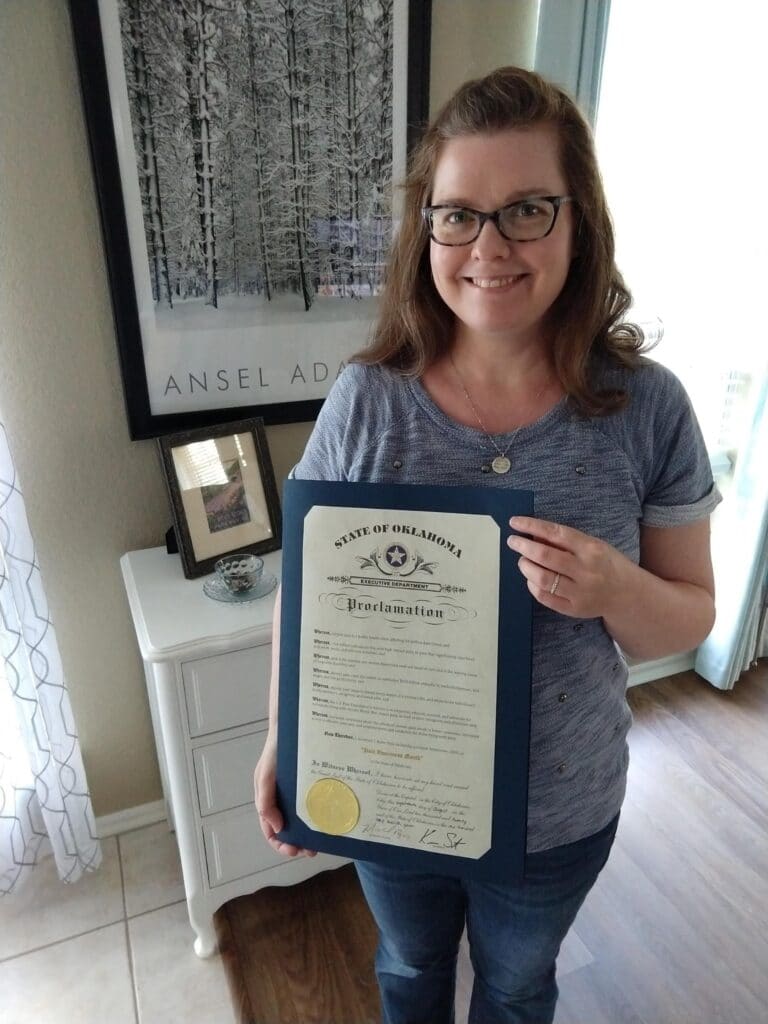 Penni Pace Mix holding the Pain Awareness Month proclamation from the state of Oklahoma. 