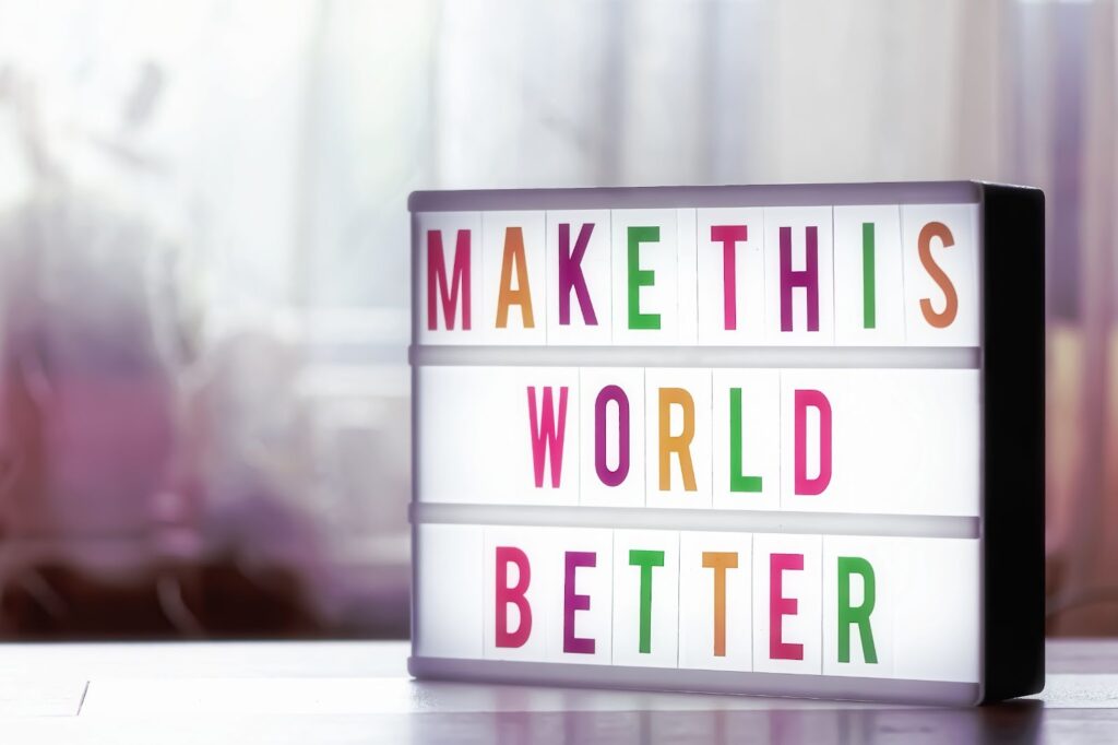 a board that says "make this world better"