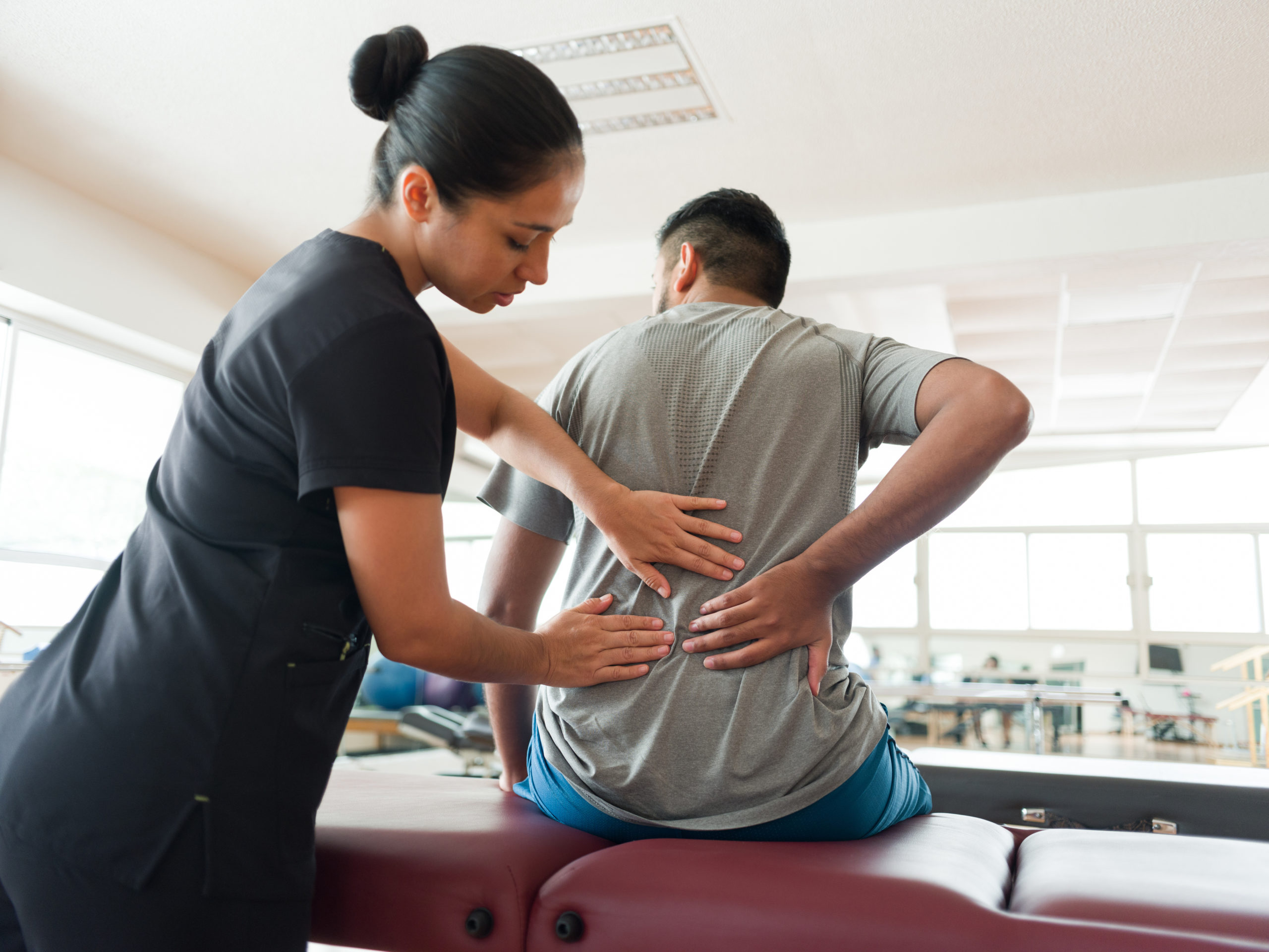 Female massage therapist massaging patient’s back